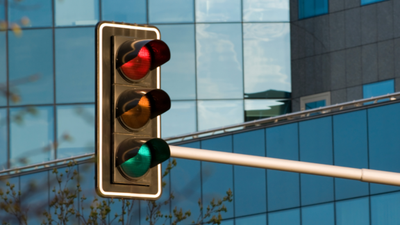 Ampel mit rotem, grünem und gelbem Licht vor Regierungsgebäude