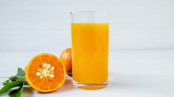 Orangensaft mit aufgeschnittener Orange